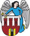 Herb Miasta Torunia: anioł trzymający tarczę herbową. Na tarczy fragment ceglanych murów, trzy wieże i brama w połowie otwarta. W prawej ręce anioła złoty klucz.